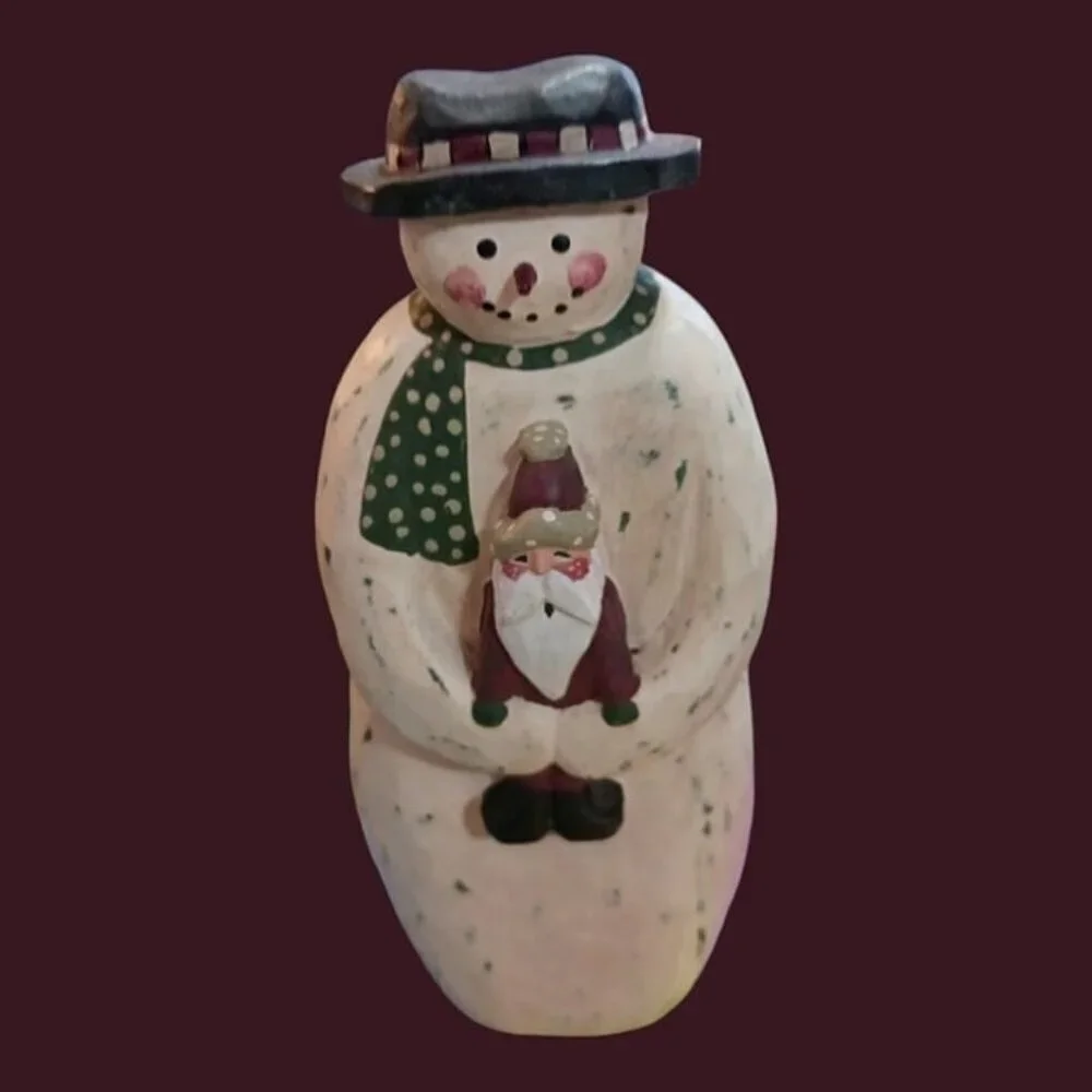 Wood snowman holding santa in his hands